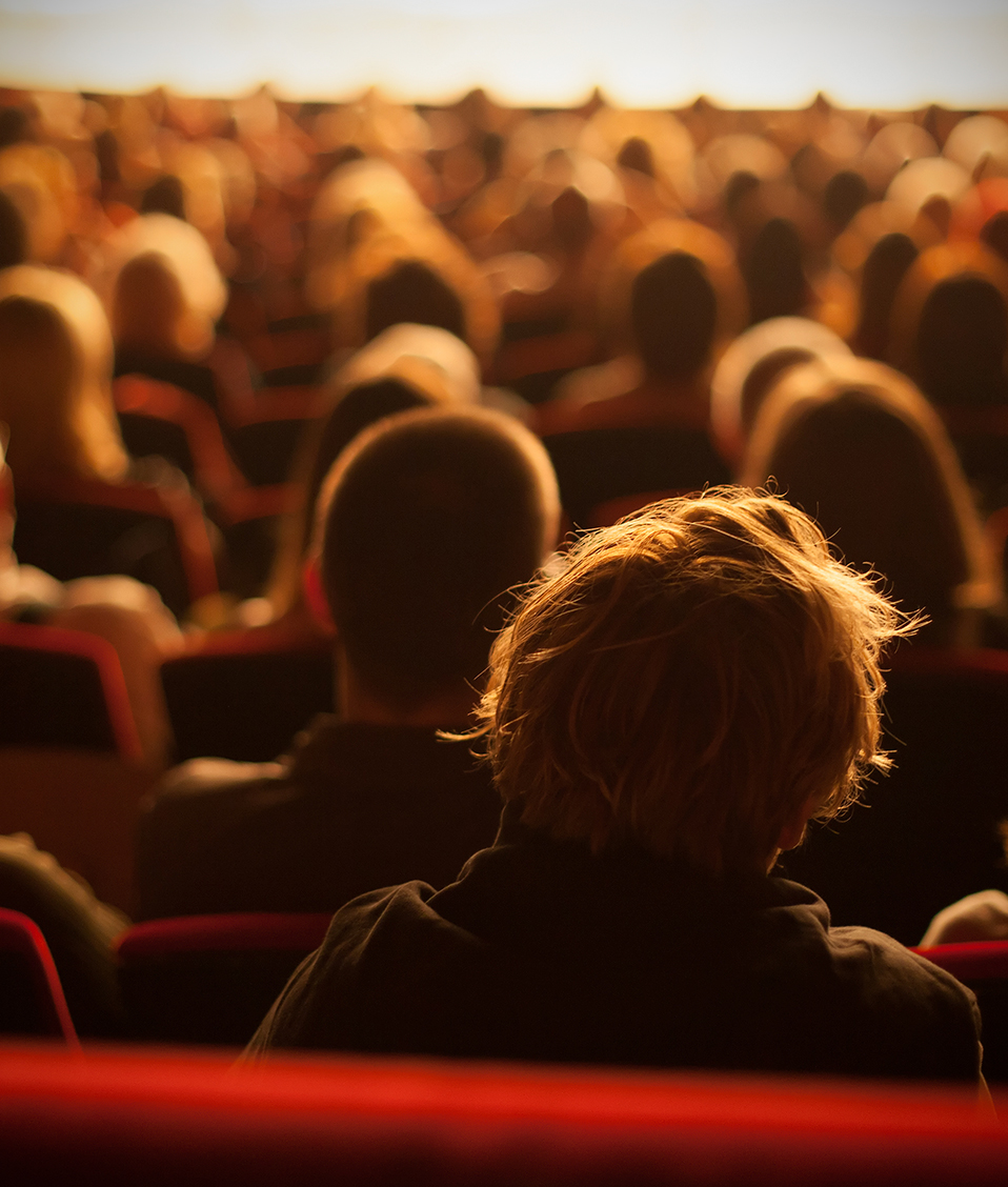 Zona de butacas de un teatro o un salón de actos repleto de gente